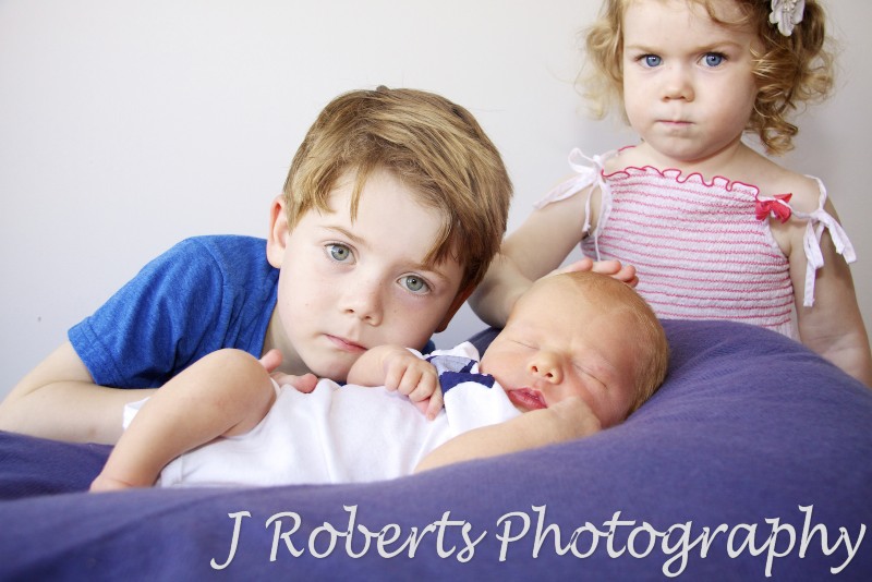 Siblings being protective of their newborn baby brother - newborn portrait photography sydney